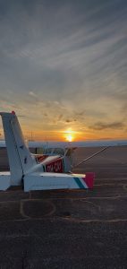 Small airplane and a sunset in horizon.

