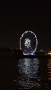 Illuminated Ferris Wheel near the river.
