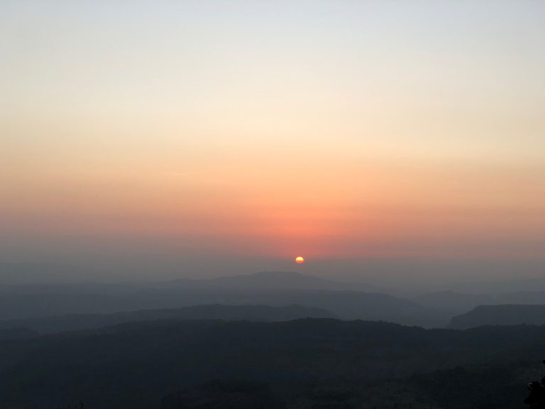 The sun sinks below the horizon, bathing the sky in a fiery glow.
The mountains are shrouded in mist, their peaks just visible above the clouds.
The sky is ablaze with color, from deep orange to fiery red.
A few wispy clouds float by, adding to the beauty of the scene.
The sunset is a reminder of the beauty of nature and the passage of time.