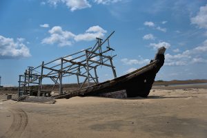 A skeleton of an old fishing boat in the sand
