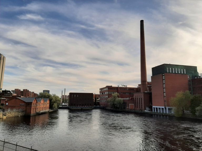 A river running through Tampere with factories and buildings on either side.