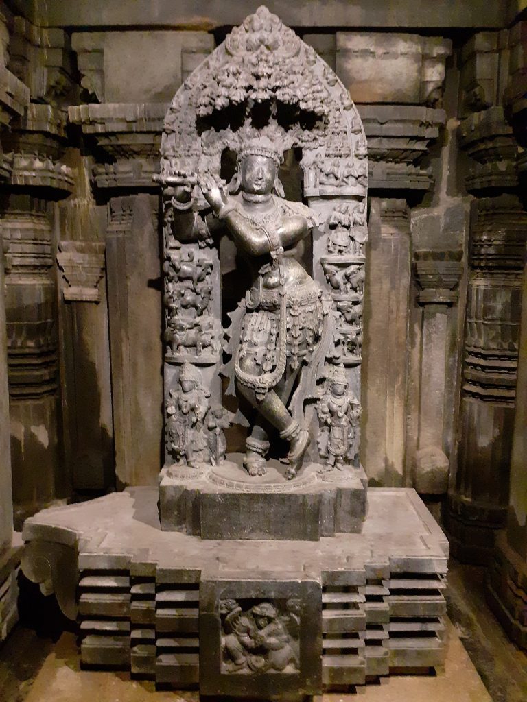 Ancient Hindu idol in a stone alcove.