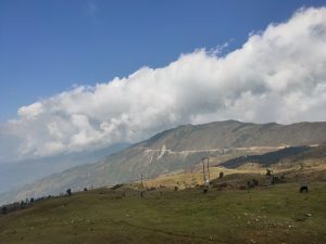 Mountain with a very wide green area and blue sky