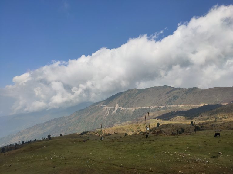 Mountain with a very wide green area and blue sky