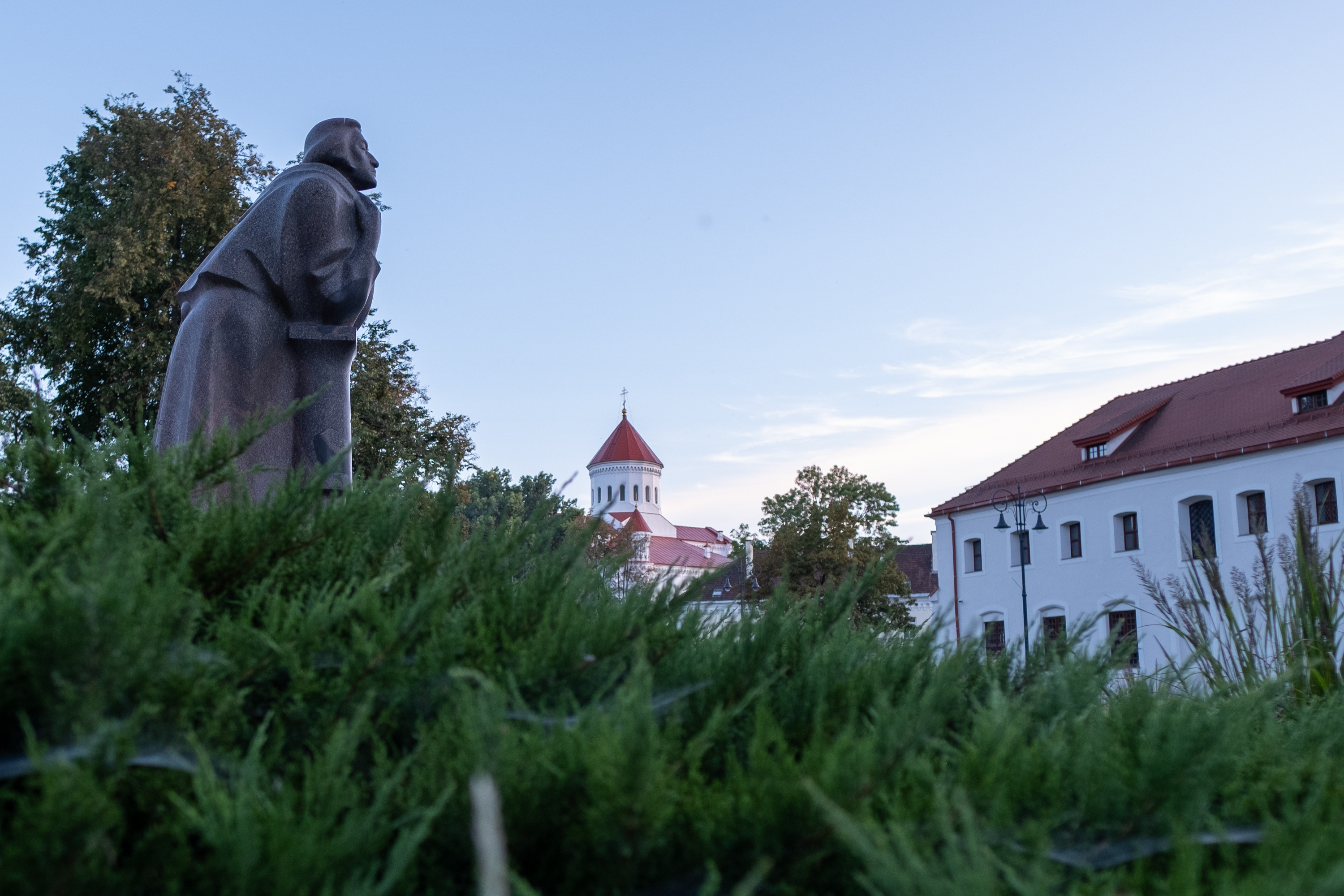 Wide angle photograph with the statue of Adam Mickiewicz on the left and the dome of the Cathedral of the Theotokos in the background. Near U?upis, Vilnius.