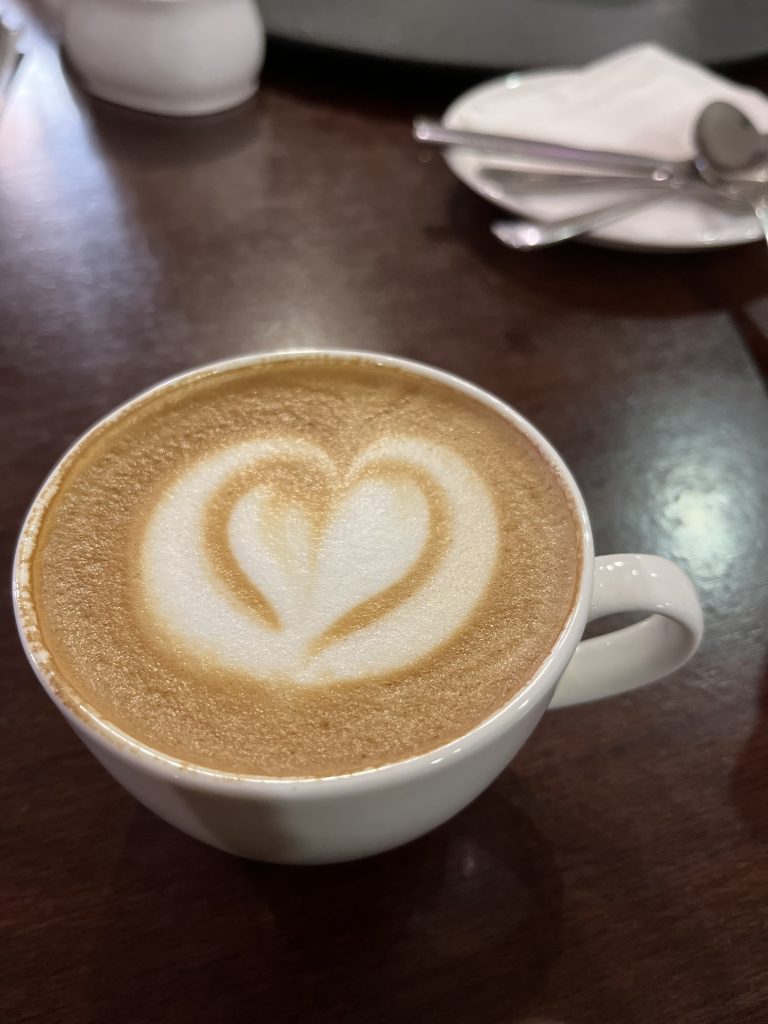 A cup of Coffee with Heart art in it.