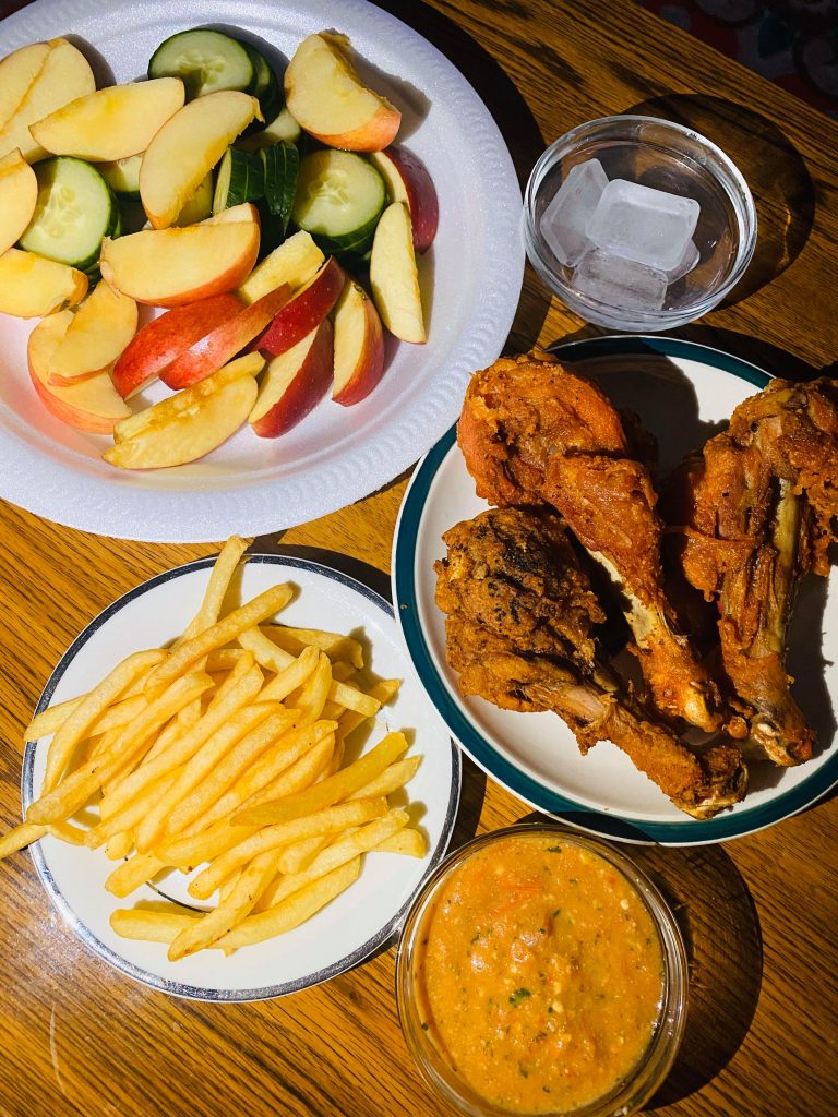 Home made Lunch with apple fruits, chicken and fries.