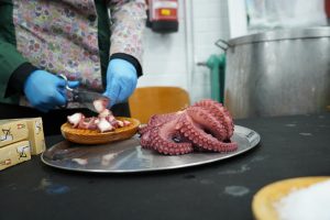 View larger photo: Cook preparing pulpo a feira (traditional octopus dish) and WordCamp Pontevedra 2023