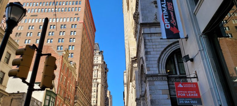 Buildings on either side with blue sky above. Walnut Street Facing West looking up at the sky.