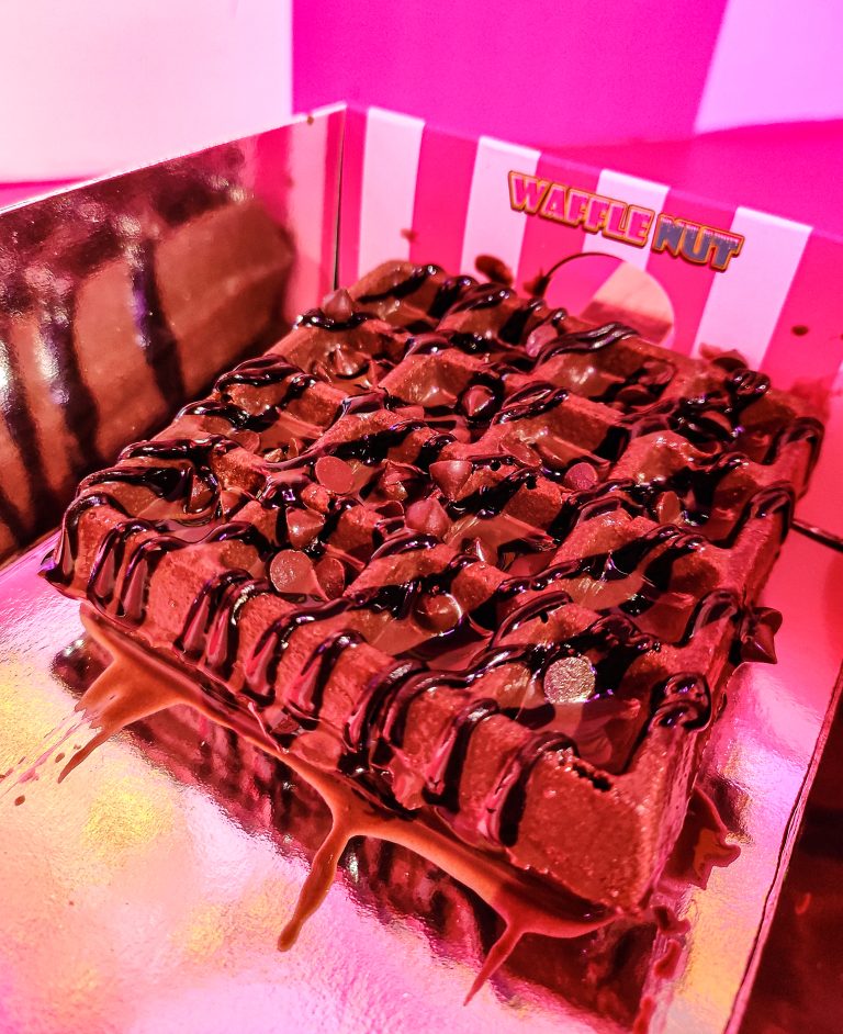 Choco Blust Waffle, a waffle covered in syrups and candy in a fancy decorated box.