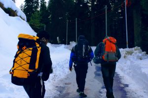 Back packers walking down a path in snow