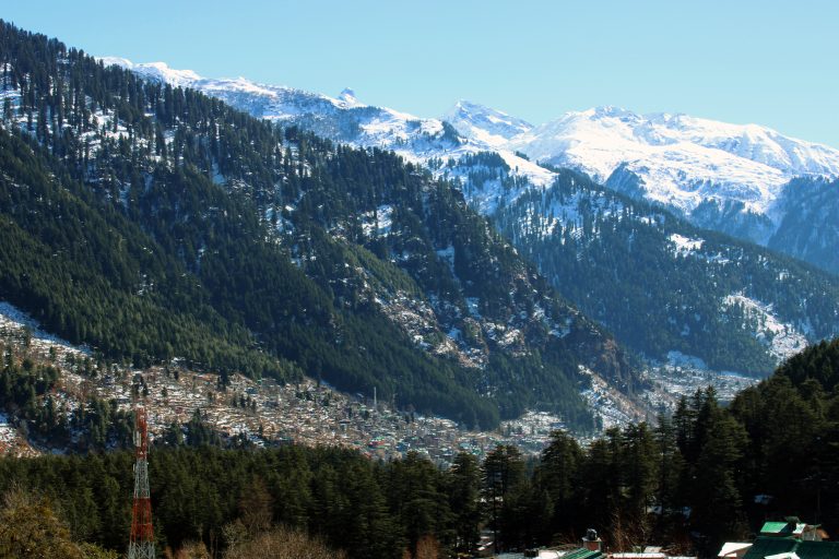 Tiny valley houses in background of Himalayas.