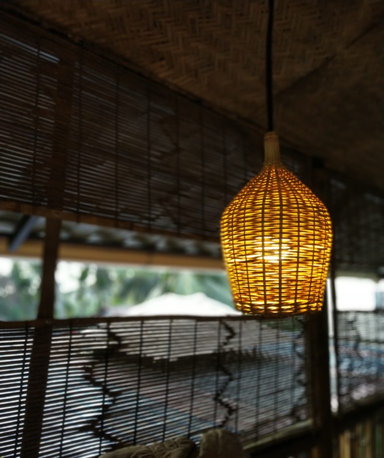 Bamboo lampshade hanging from a ceiling