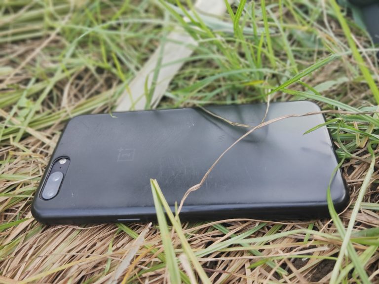 A cell phone facedown on the grass