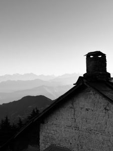 A cabin and Himalayan mountain ranges in the background.  