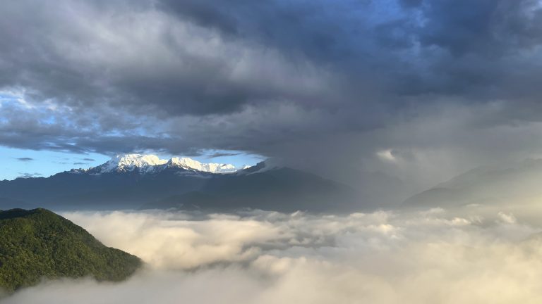 Beautiful Annapurna Range at Pokhara taken from the top of a mountain above cloud level looking upon a misty vista to snow capped mountain in the distance.