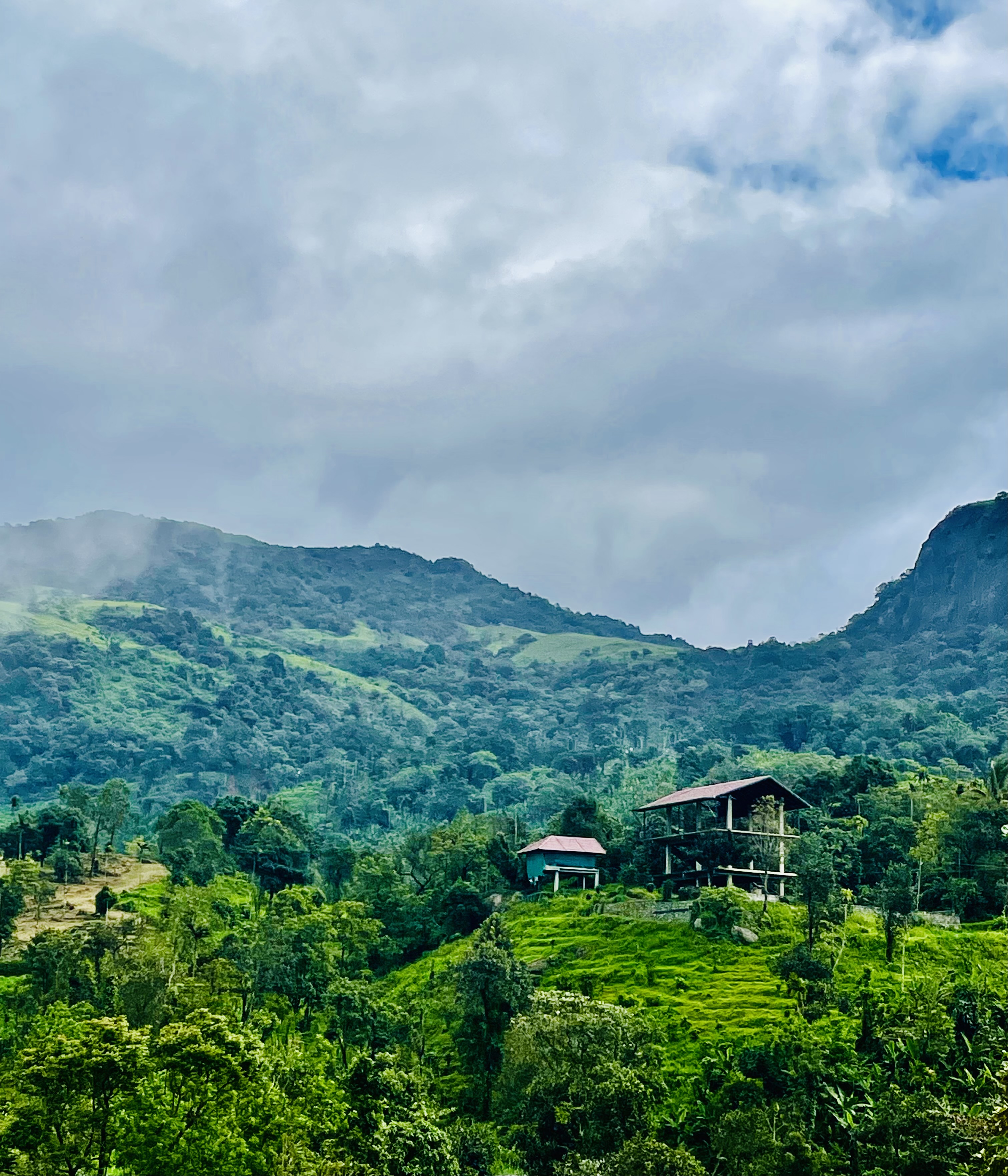 A view of green hills and cloudy sky in Kurisumala, Malappuram, Kerala, India