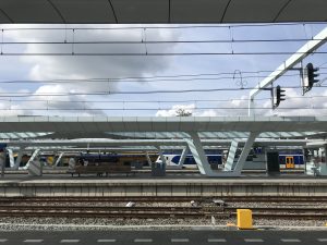 Arnhem Centraal train station: parallel lines of electric wires, platforms, and trains
