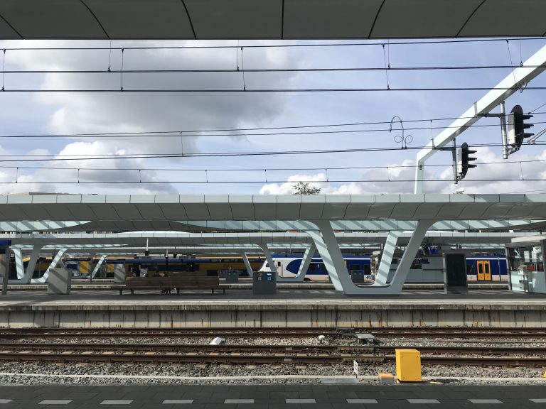 Arnhem Centraal train station: parallel lines of electric wires, platforms, and trains