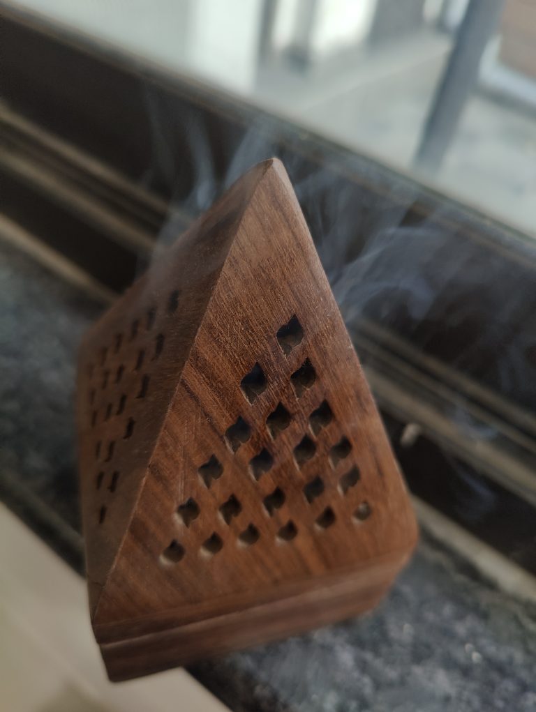 Incense smoke coming from a traditional wooden box.