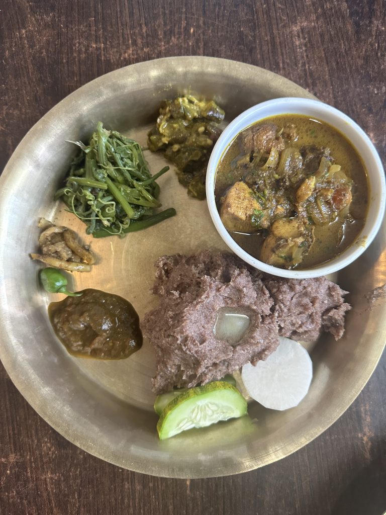 Traditional Nepali food dhindo along with chicken curry, tomato pickel, green vegetables, etc.