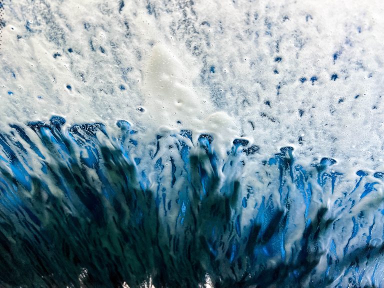 In the car wash. Looking at the windshield from the inside as the soap and scrubbers do their work.