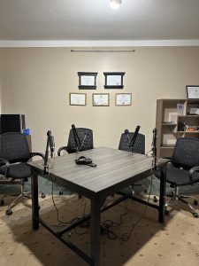 A podcast set. It has four chairs, four microphones and a table. 