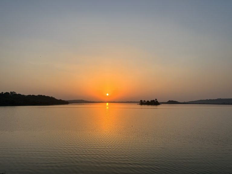 Sunrise reflecting on tranquil waters, painting the morning with hues of gold and serenity.