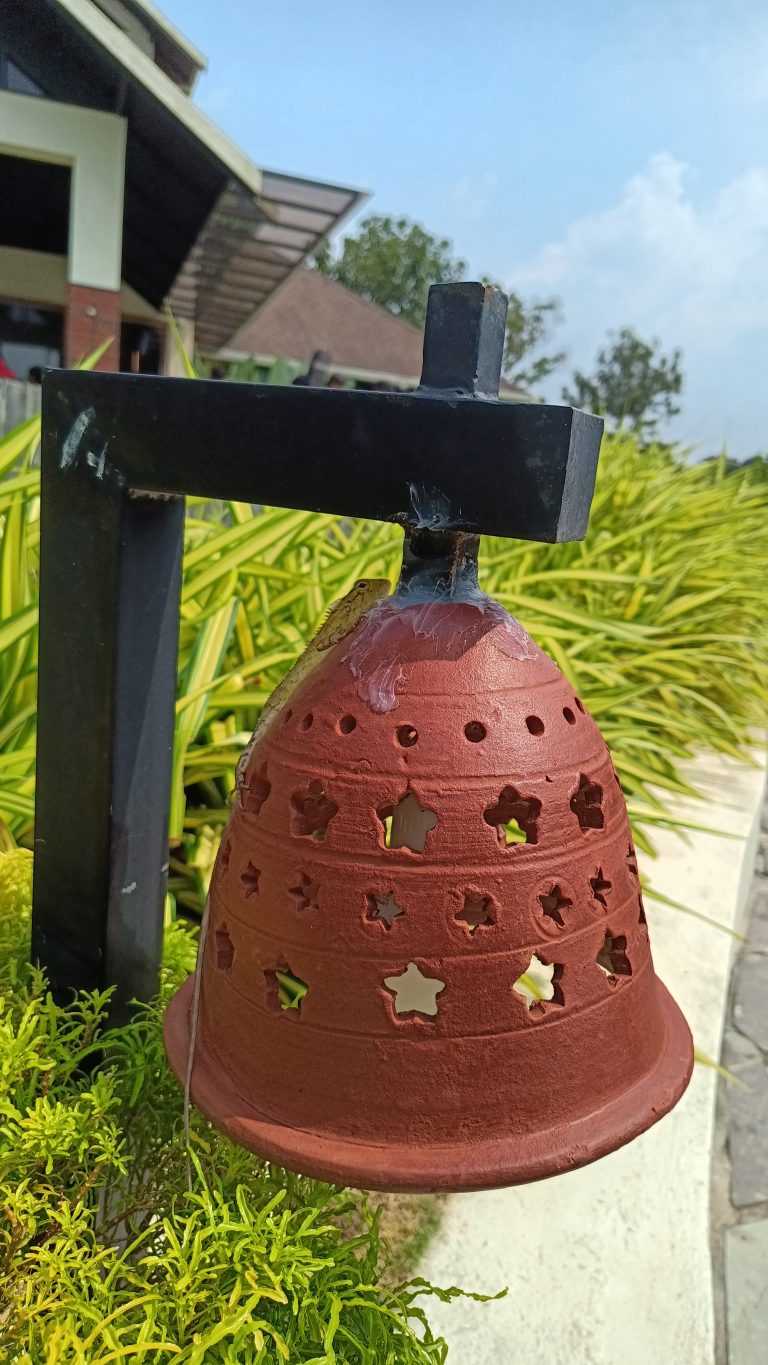 An oriental yellow gardern lizard sitting on a Lamp Shade made up of clay.