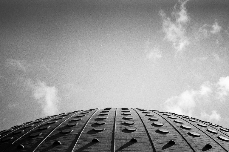 Black and white view of the strange roof of Porto’s Super Bock Arena under a cloudy sky.