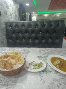 View larger photo: Table and bench seat with food on the table. 