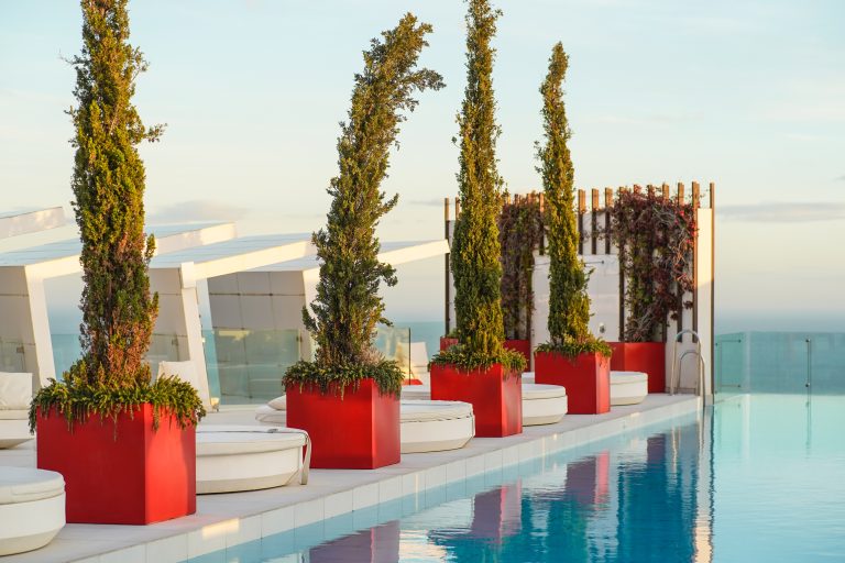 Infinity pool at a hotel rooftop, side detail. blue, red, white, sky, water, luxury