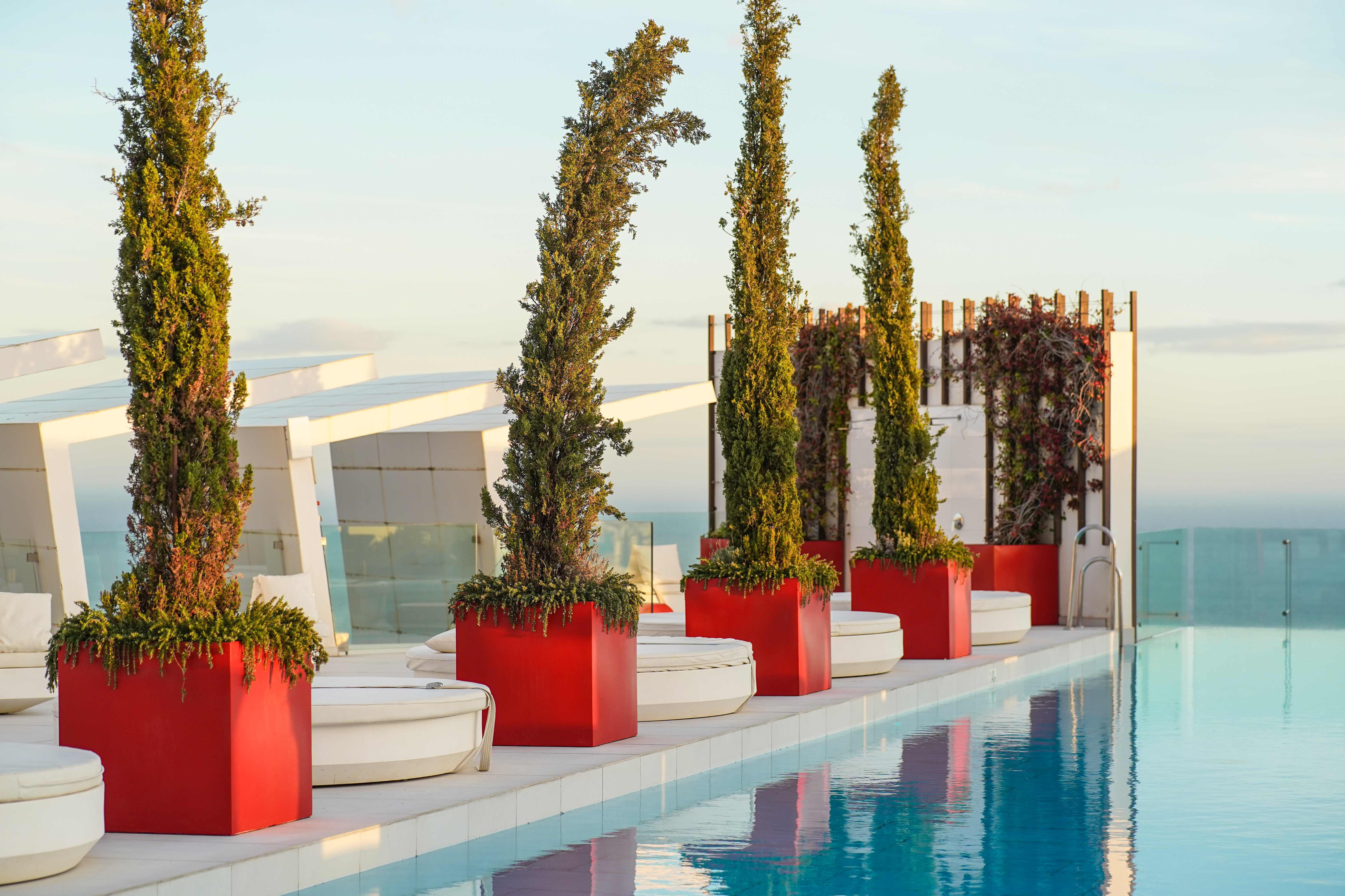 Infinity pool at a hotel rooftop, side detail. blue, red, white, sky, water, luxury