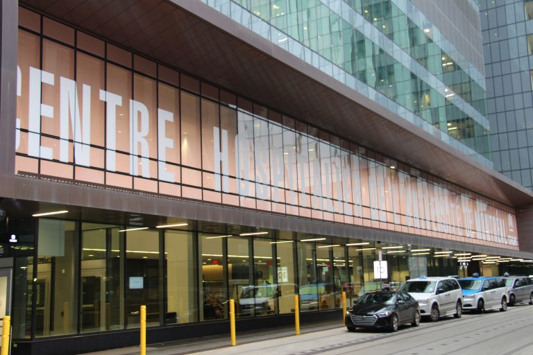 Universite de Montreal CHUM, beautiful building, architecture. Street view, cars parked out front.