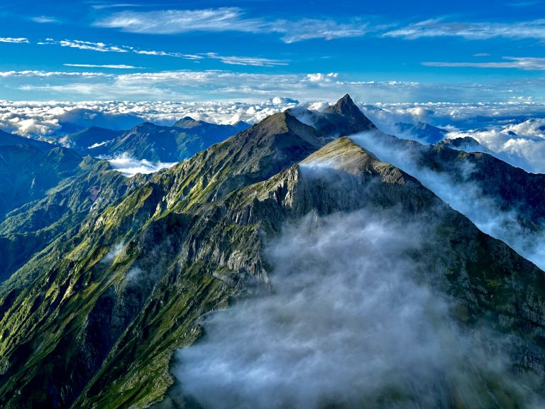 Daikiretto Ridge cuts through the sea of clouds in the Japanese Northern Alps Yari-Hotaka circuit, the crown jewel among all the mountain trailing hikes available in Japan. Mount Yari’s spear-like summit is perfectly visible in the background. This image was taken from the Kitahotaka Mountain Hut.