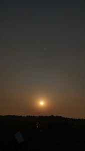 An orange sun against a dark sky