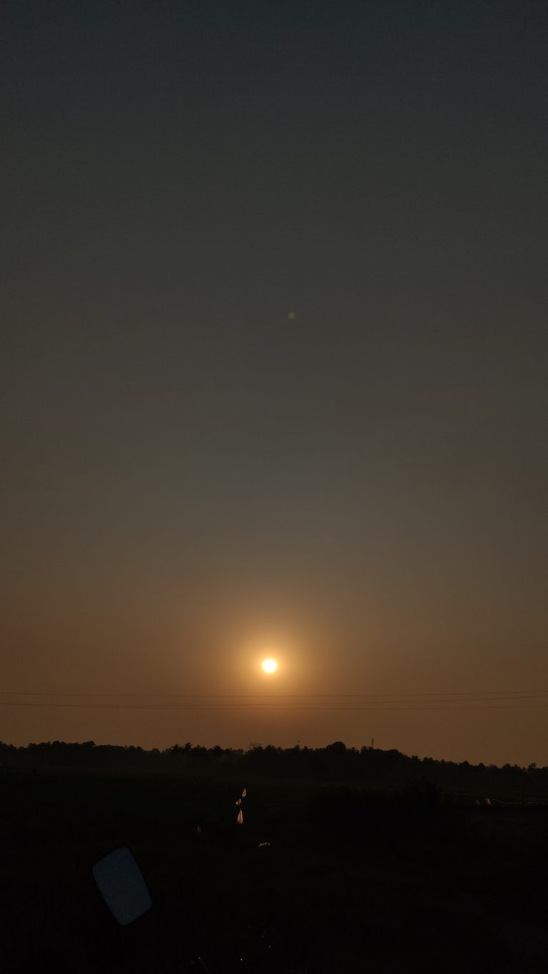 An orange sun against a dark sky