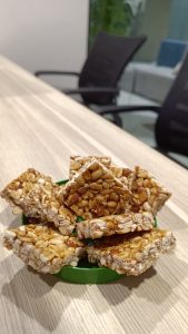 A bunch of peanut chikki commonly known as "Kadala Midayi" taken in a green jar cap sitting on a table.