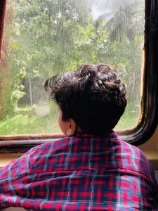 A boy looking through the window of train.