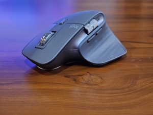 A computer mouse resting on a wooden table. 