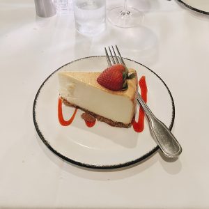 A Slice of cheesecake on a plate with a fork next to it