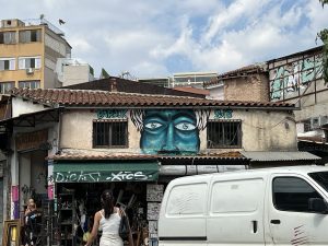 A mural of a person looking out over the marketplace in Athens.