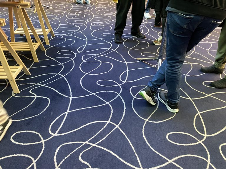 Blue swirly carpet with designer shoes.