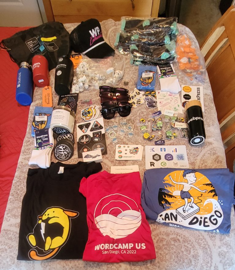 A display of different swag including t-shirts from WordCamp US