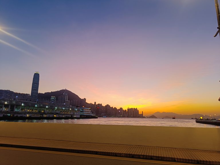 Sunset view of a river flowing next to a city.