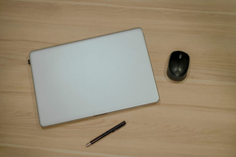 Top view of laptop, Mouse and Pen on wooden table