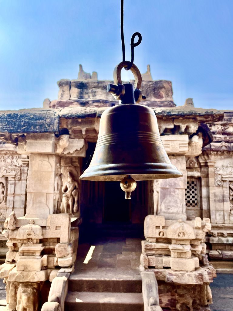 An ancient suspended brass bell originating from the Pattadakal temple complex in Karnataka.