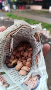 Peanuts that are packed in a traditional cone shaped paper pack made of newspaper