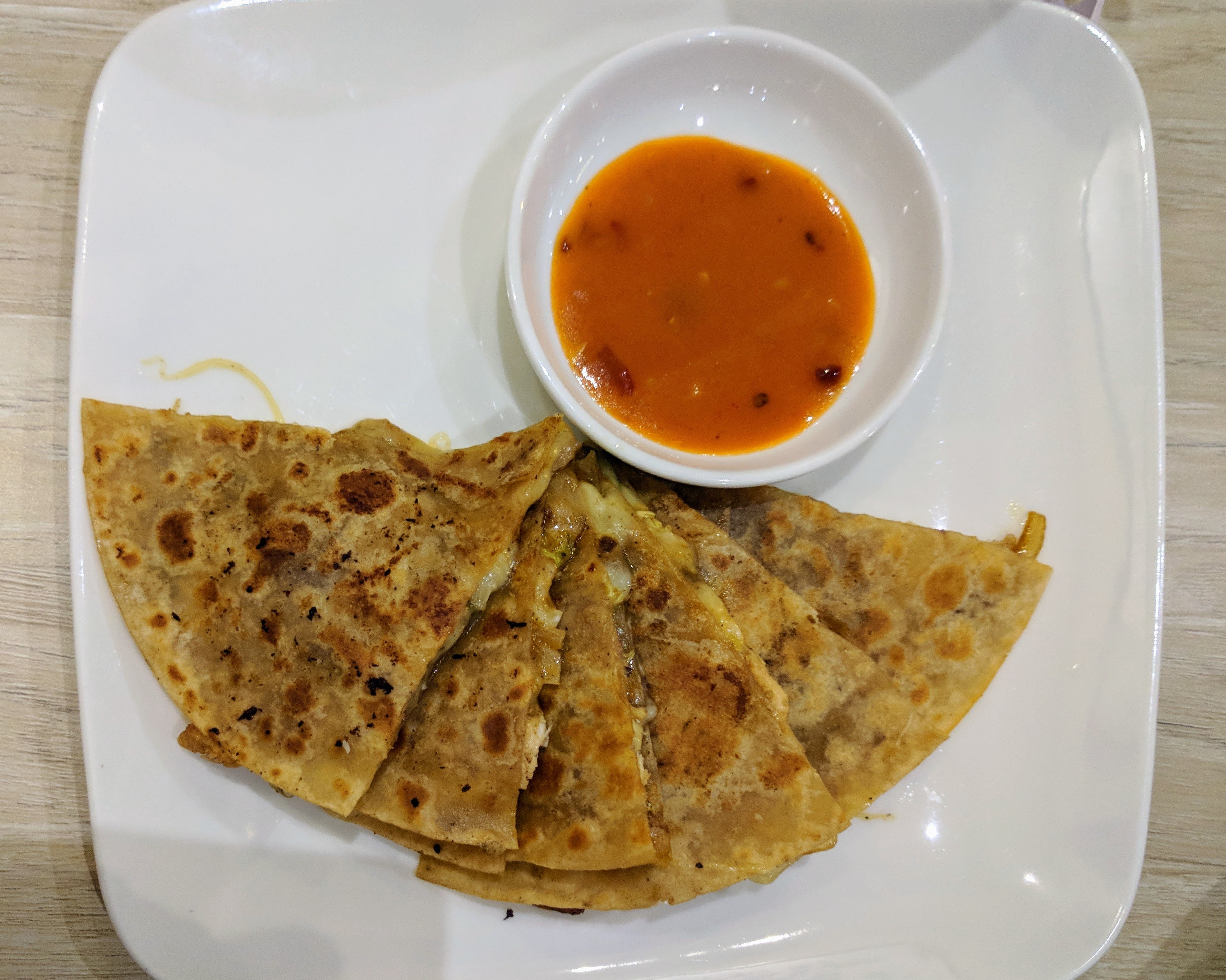 Roti stuffed with cheese, chicken, and veggies with tomato chutney.