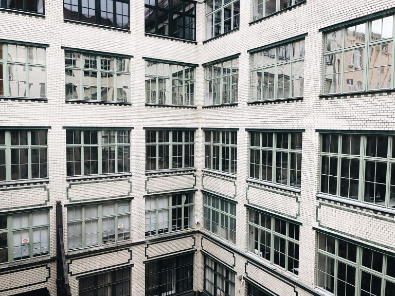 Windows and walls of small white bricks inside the Luisenstad courtyard, in Berlin.